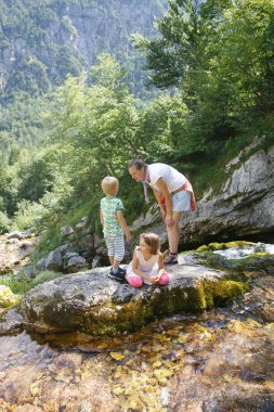 Eğleniyor, bir dağ dere tarafından yaz aylarında çalan çocuk anne. 
