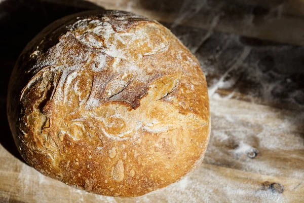 Pão caseiro fresco feito de massa de fonte descansando em um rack de arame. Pão artesanal com crosta crocante dourada . — Fotografia de Stock