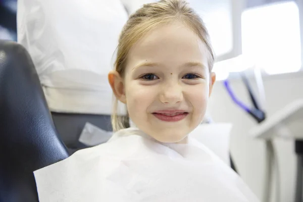 Sorrindo menina no consultório odontológico . — Fotografia de Stock