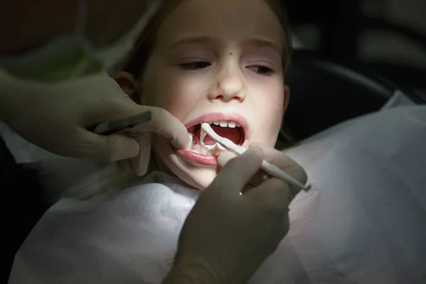 Niña asustada en el consultorio de dentistas, con dolor durante un tratamiento . —  Fotos de Stock