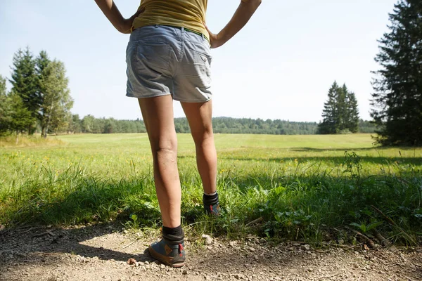 Жінка з болючими венами на ногах відпочиває на прогулянці через природу . — стокове фото