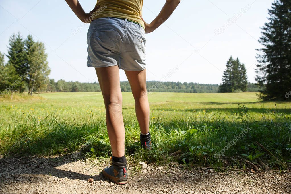 Woman with painful varicose veins on legs resting on a walk through nature. 
