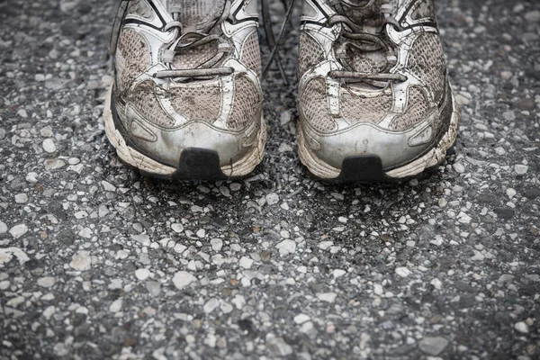 Opotřebované, špinavá, páchnoucí a staré tenisky na asfaltovou silnici. — Stock fotografie