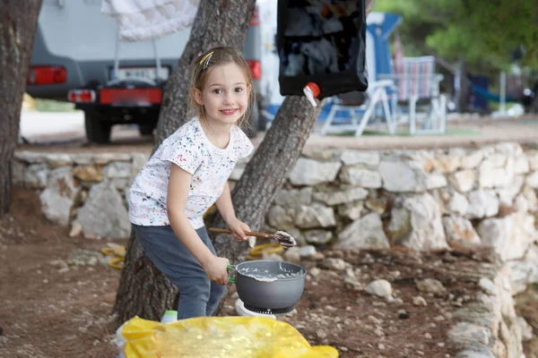 Girl at the campsite, cooking food in outdoor kitchen. — Stock Photo, Image