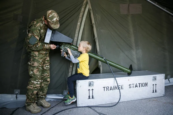 Soldier introducing anti-aircraft air defence simulator to a boy chil