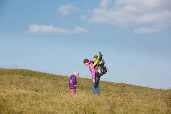 Мама з дітьми ходить в гарний осінній день у пошуках диких трав — стокове фото