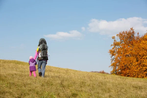 Mère avec des enfants randonnée sur une belle journée d'automne portant enfant — Photo