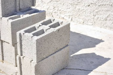 İnşaatta kullanılan beton bloklar grubu. Arka planda beton duvar ile.