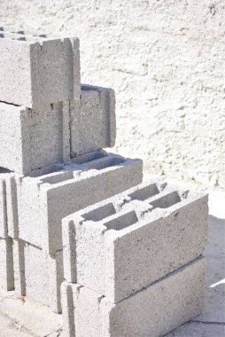 İnşaatta kullanılan beton bloklar grubu. Arka planda beton duvar ile.