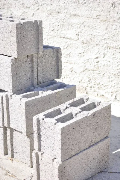 İnşaatta kullanılan beton bloklar grubu. Arka planda beton duvar ile.