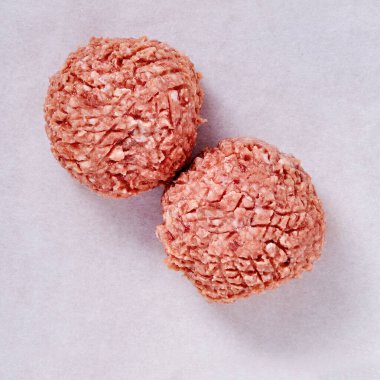 Bir stüdyo ortamındaki çiğ köftelerin üst görüntüsü, beyaza izole edilmiş..
