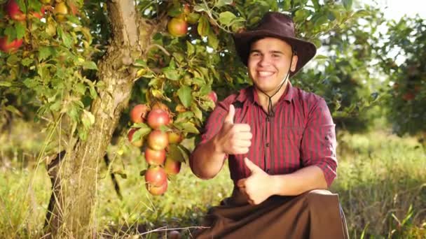 リンゴ園の親指をやって笑顔の農家の肖像画 — ストック動画