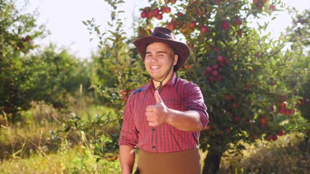 Retrato del agricultor parado en el jardín y levantando grandes dedos de las manos . — Vídeo de stock