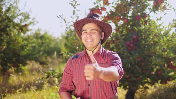 Portret rolnik stojący w ogrodzie i umieścić duże palce rąk. — Wideo stockowe