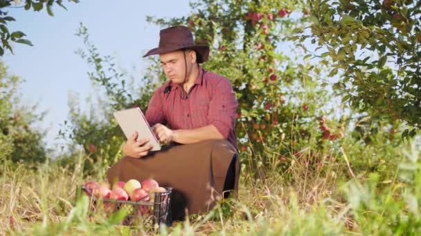 Farmář pomocí digitálních tabletu apple zahradě. — Stock video