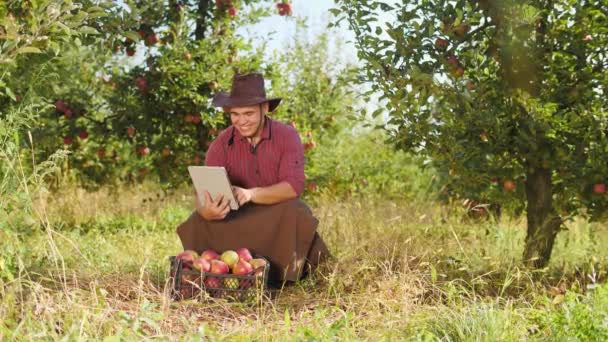 Agricultor usando tablet digital no jardim da maçã . — Vídeo de Stock