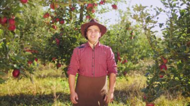 Elma bahçesinde yukarı çiftçi başparmak gösterilen şapkalı portresi