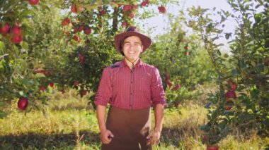 Elma bahçesinde yukarı çiftçi başparmak gösterilen şapkalı portresi