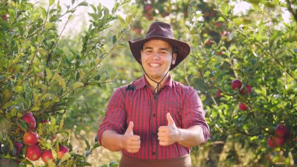 Портрет фермера, стоящего в саду и протянувшего большие пальцы рук . — стоковое видео