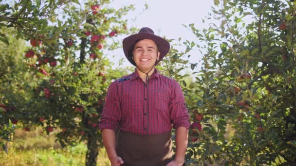 Portrait d'agriculteur en chapeau montrant les pouces vers le haut dans le jardin de pommes — Video