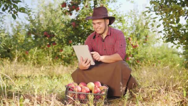 Farmář pomocí digitálních tabletu apple zahradě. — Stock video