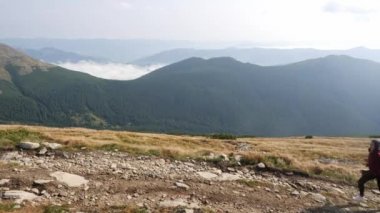 Kadın bir dağ sırtı tırmanışı koşuyor.