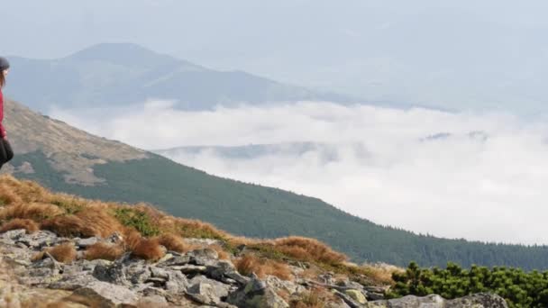 Mujer bajando a través de un valle de piedra en la montaña — Vídeos de Stock