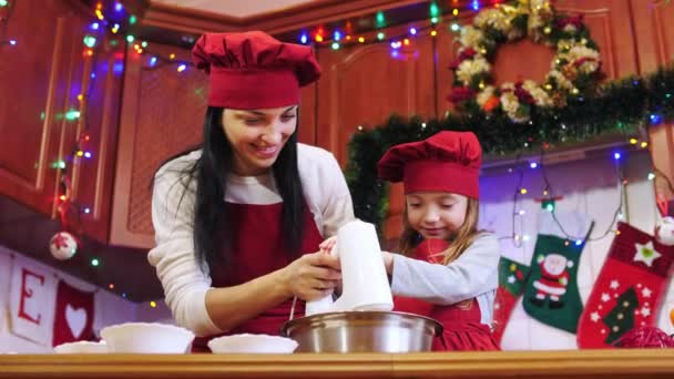 Madre enseña a su hija a mezclar ingredientes con mezclador eléctrico . — Vídeos de Stock