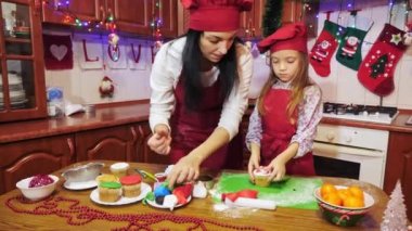 Anne ve kızı şeker mastik ile Noel kek dekorasyon vardır