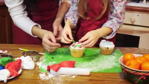 Madre besando a su hija durante la decoración de cupcake — Vídeos de Stock