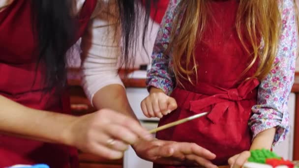 Крупный план матери и дочери украшают сахарной мастикой кекс — стоковое видео