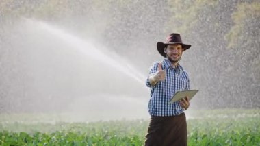 Çiftçi onun ekimi dijital tablet kullanarak izleme sırasında yukarı başparmak gösterir