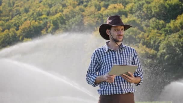 Agriculteur utilisant une tablette numérique pendant le suivi de sa plantation . — Video