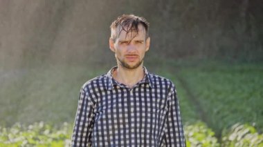 Yağmur altında duran üzgün bir adam portresi