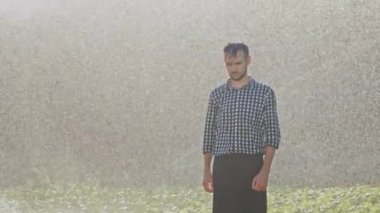 Yorgun çiftçi plantasyon sulama sırasında daimi.