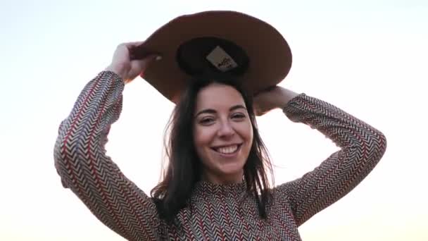 Αξιολάτρευτο νεαρό κορίτσι με καπέλο χαμογελώντας ποζάρουν στην κάμερα — Αρχείο Βίντεο