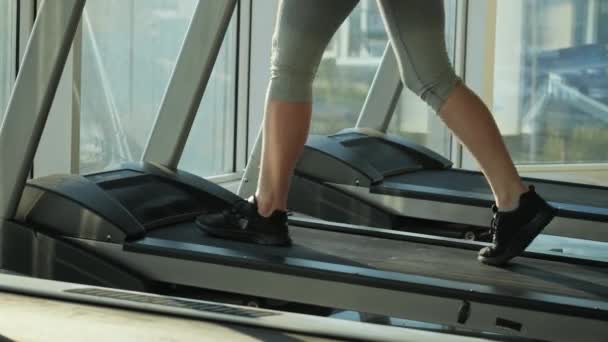 Femeia atractivă de vârstă mijlocie aleargă pe moara de rulare în sala de sport — Videoclip de stoc