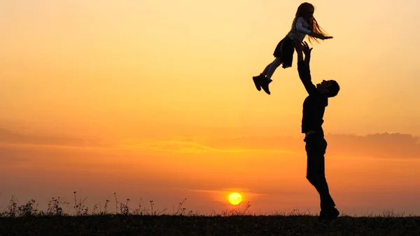 Las siluetas del niño feliz se precipita en las manos del padre . —  Fotos de Stock