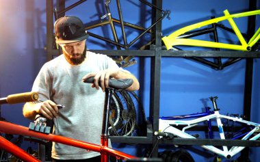 Tamirci bisiklet koltuğunu bisiklet çerçevesine sabitler