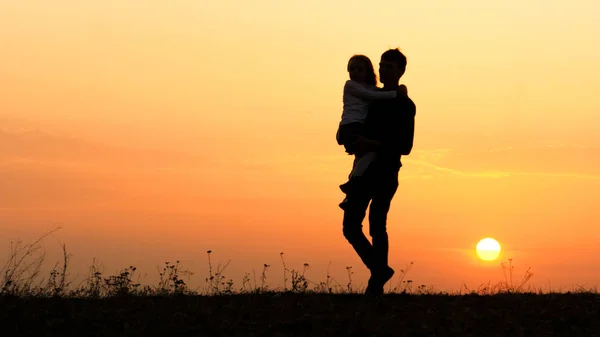 Siluetas de un niño feliz en los brazos del padre . — Foto de Stock