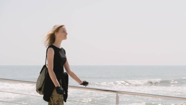 Yaz sıcağında deniz kenarında kaykaylı güzel sarışın bir kız.