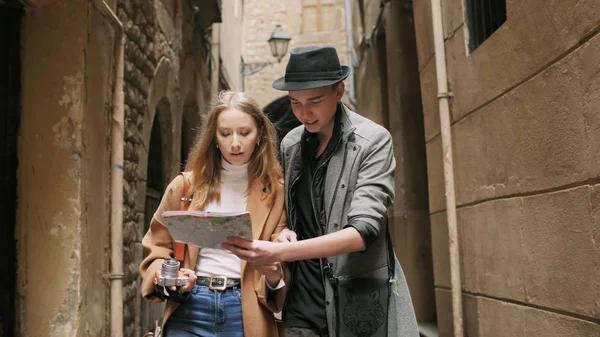 Due amici alla moda in piedi sulla strada e cercare qualcosa utilizzando una mappa — Foto Stock