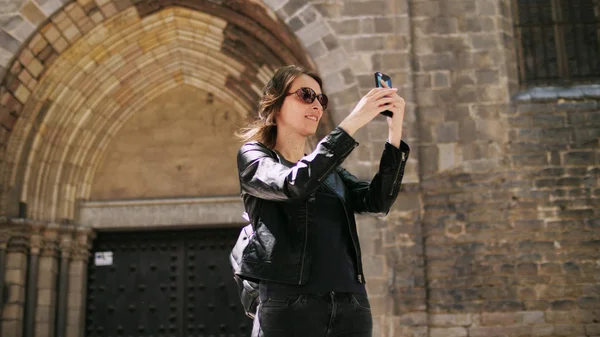 Attraente donna turistica che fa un selfie utilizza uno smartfone mentre cammina per strada. — Foto Stock
