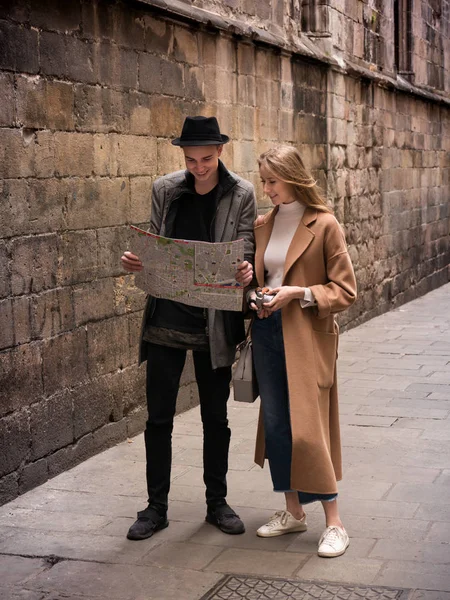 Amici belli e in stile a piedi con mappa e macchina fotografica attraverso la strada . — Foto Stock