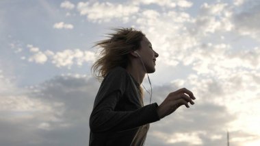 Çatı katında dans kulaklık, müzik dinleme sırasında mutlu hissediyor kadın.