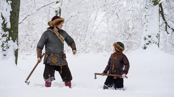 父バイキングは、手の斧を保持し、戦いのために彼の息子を教えます. — ストック写真