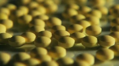 Cam masaya saçılmış sarı haplar.