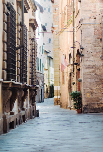 Street of the old town of Italy, with beautiful window sills with medieval wrought iron bars.