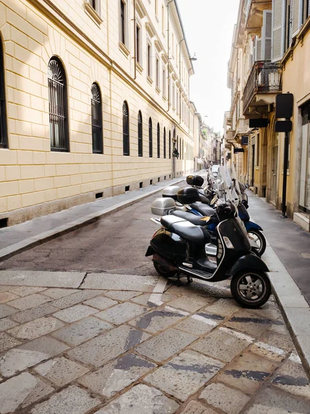 The narrow street of the old medieval city of Italy, the beautiful architecture of the houses. Scooter parking. — Stock Photo, Image