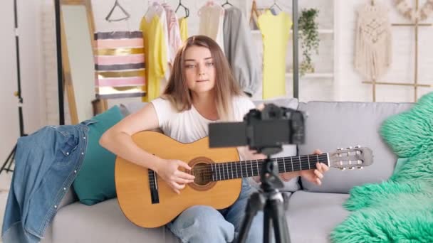 Atractivo adolescente chica vlogging durante jugar en una guitarra. — Vídeo de stock